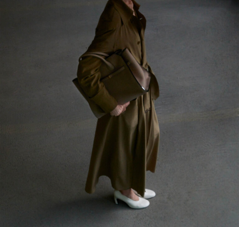 Woman wearing a Milano two handle bag in beige brown colour  soft suede leather