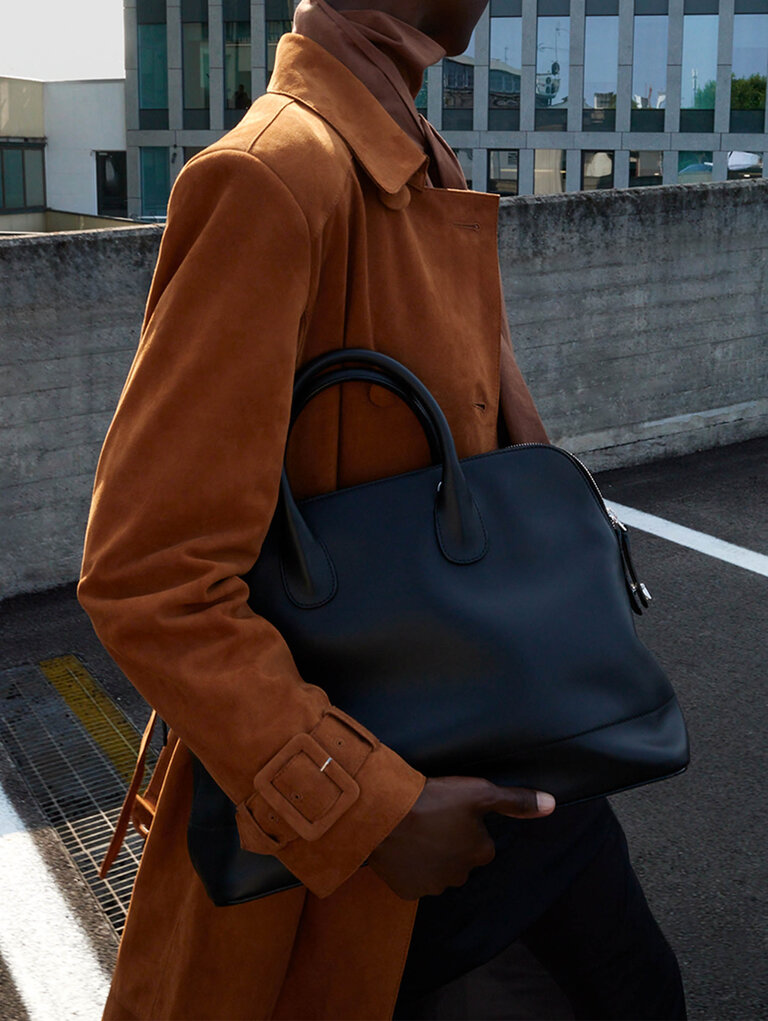 Woman carring a valextra mylogo bowling bag in black smooth leather